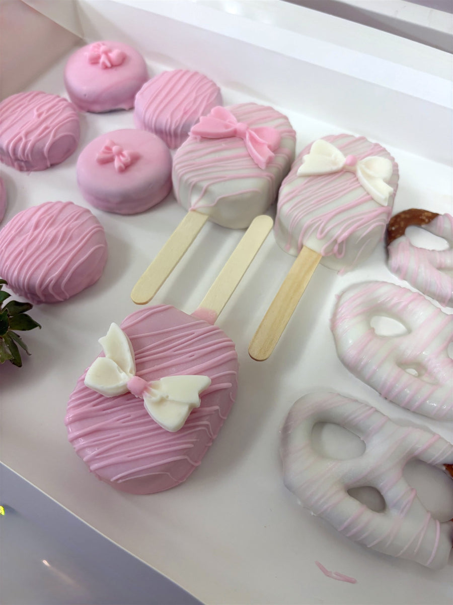 Pink party assortment of dipped treats, cakesicles and pretzels